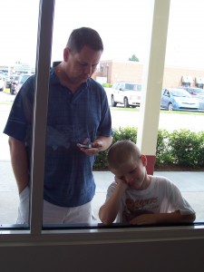 Husband and Kid Bide Their Time at the Outlets